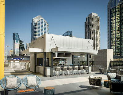 Rooftop bar surrounded by high rise buildings on a sunny day