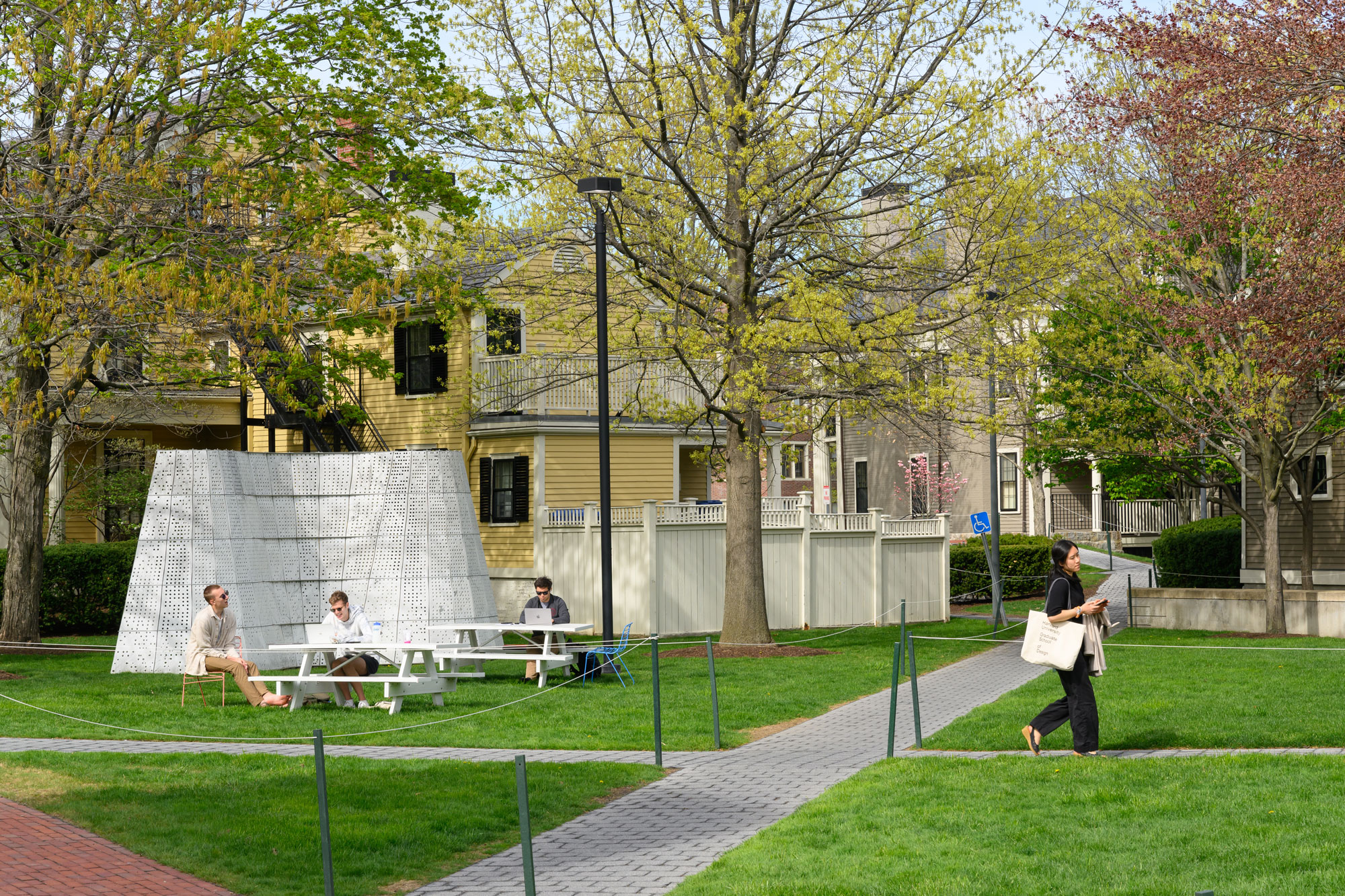 A few of Gund Hall backyard with students passing through